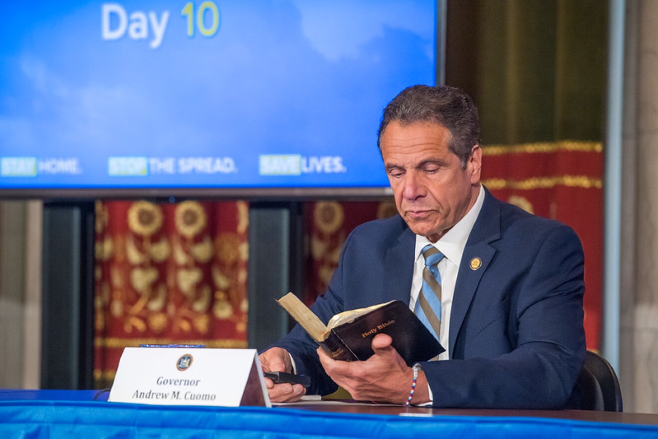 Gov. Andrew Cuomo reads from the Bible to make a point about peaceful protests at his daily briefing on Wednesday.